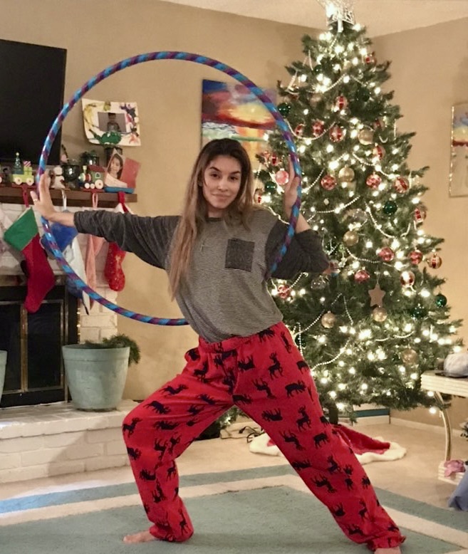 Person stretching with a 3/4 inch hoop at a Christmas Sunshine Hoops event