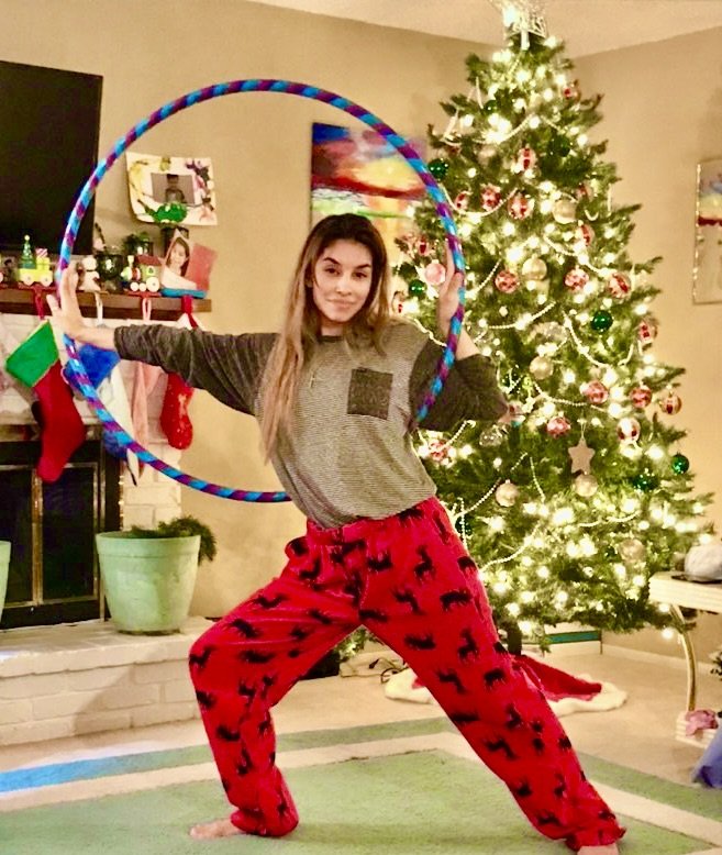 Sunshine Hoops instructor doing a lunge stretch with a 3/4 inch hoop in front of a Christmas tree