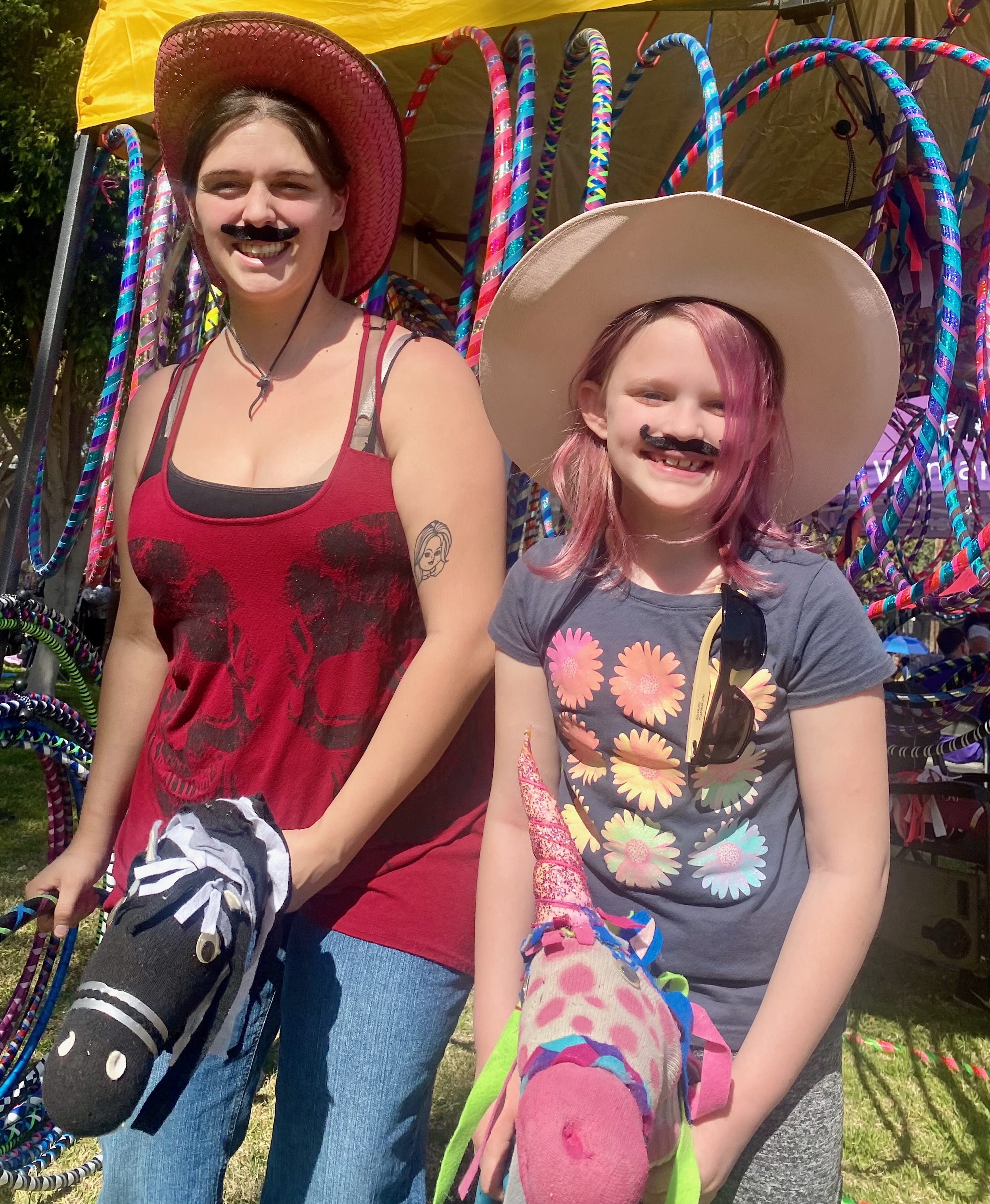 Stick-Pony Rodeo fun with cowboy hats and mustaches in front of colorful hoop display