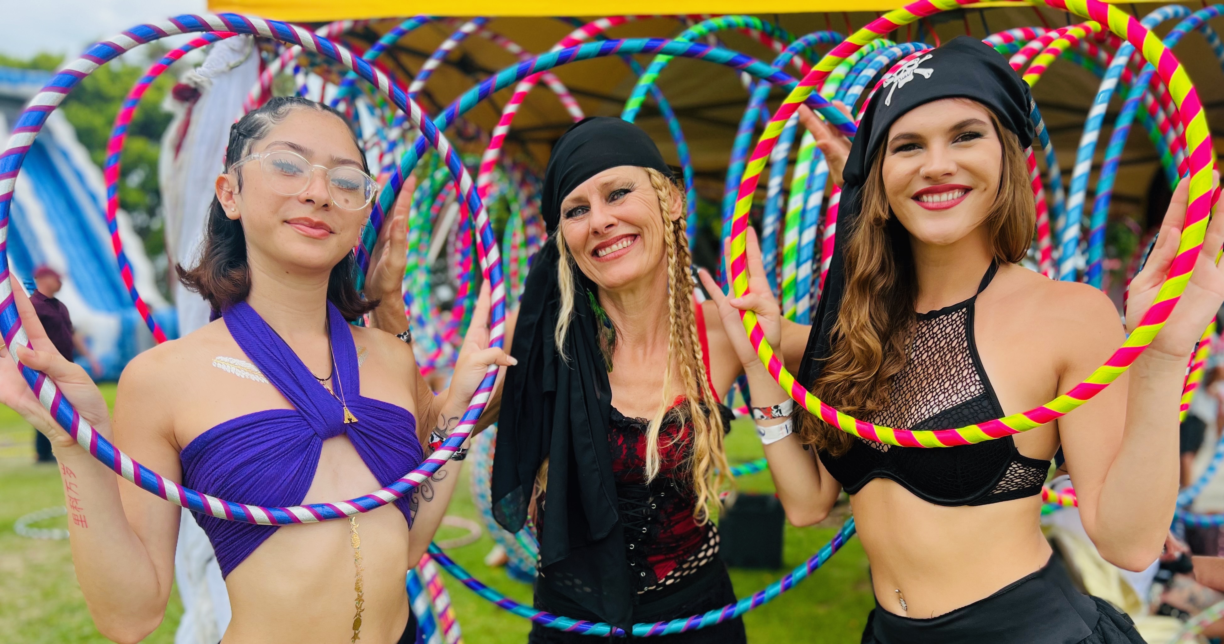 Three Sunshine Hoops instructors with colorful hoops at festival