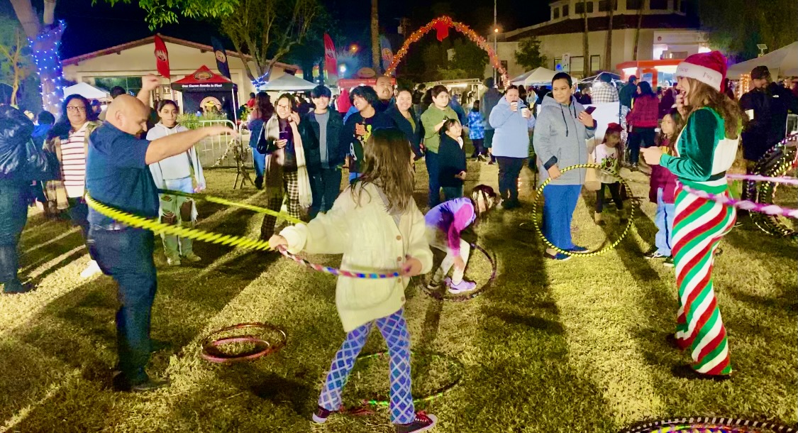 Families hooping together at a Christmas night event with Sunshine Hoops elf instructor