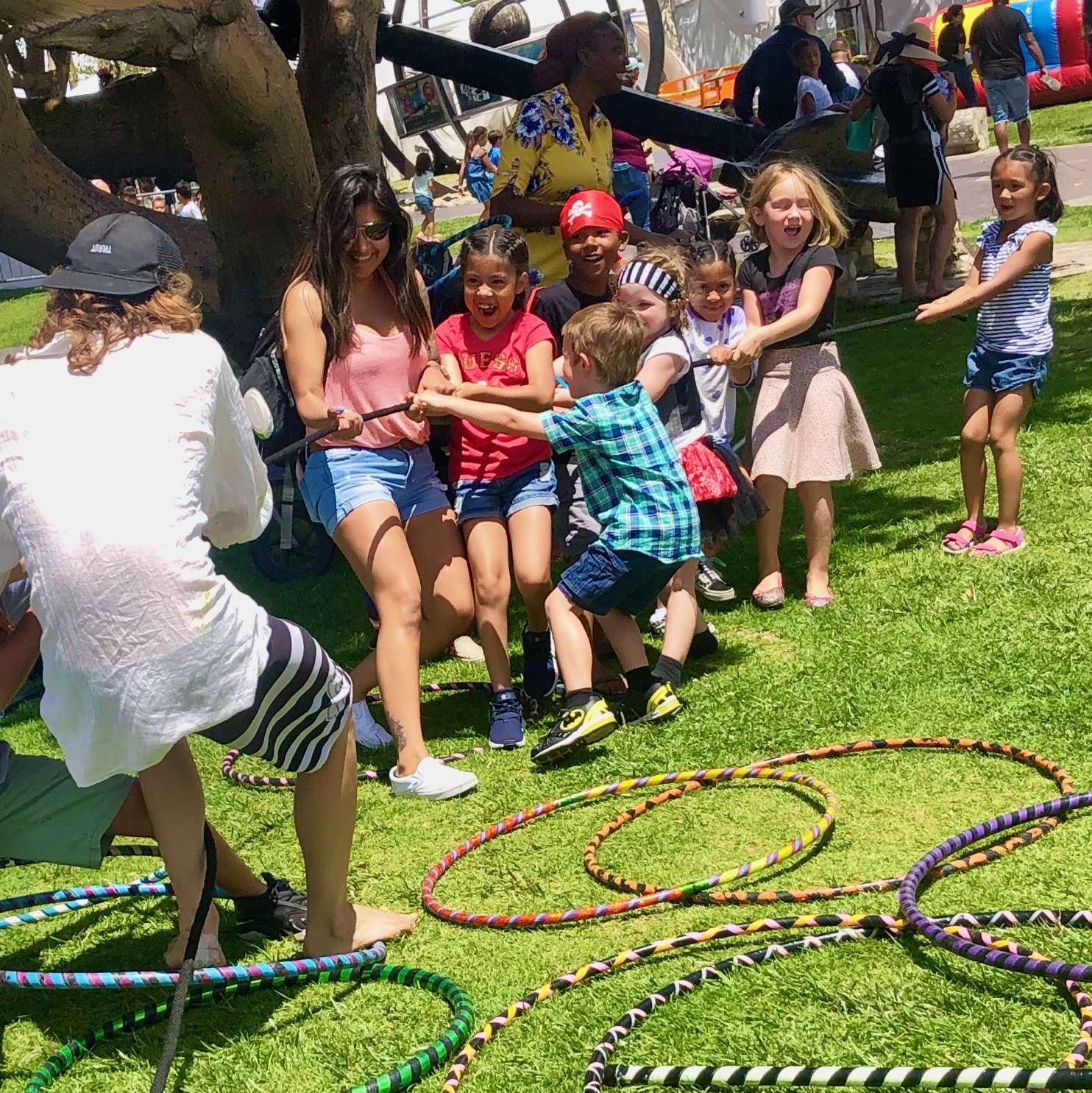 Kids and adults playing tug-of-war at a Sunshine Hoops party