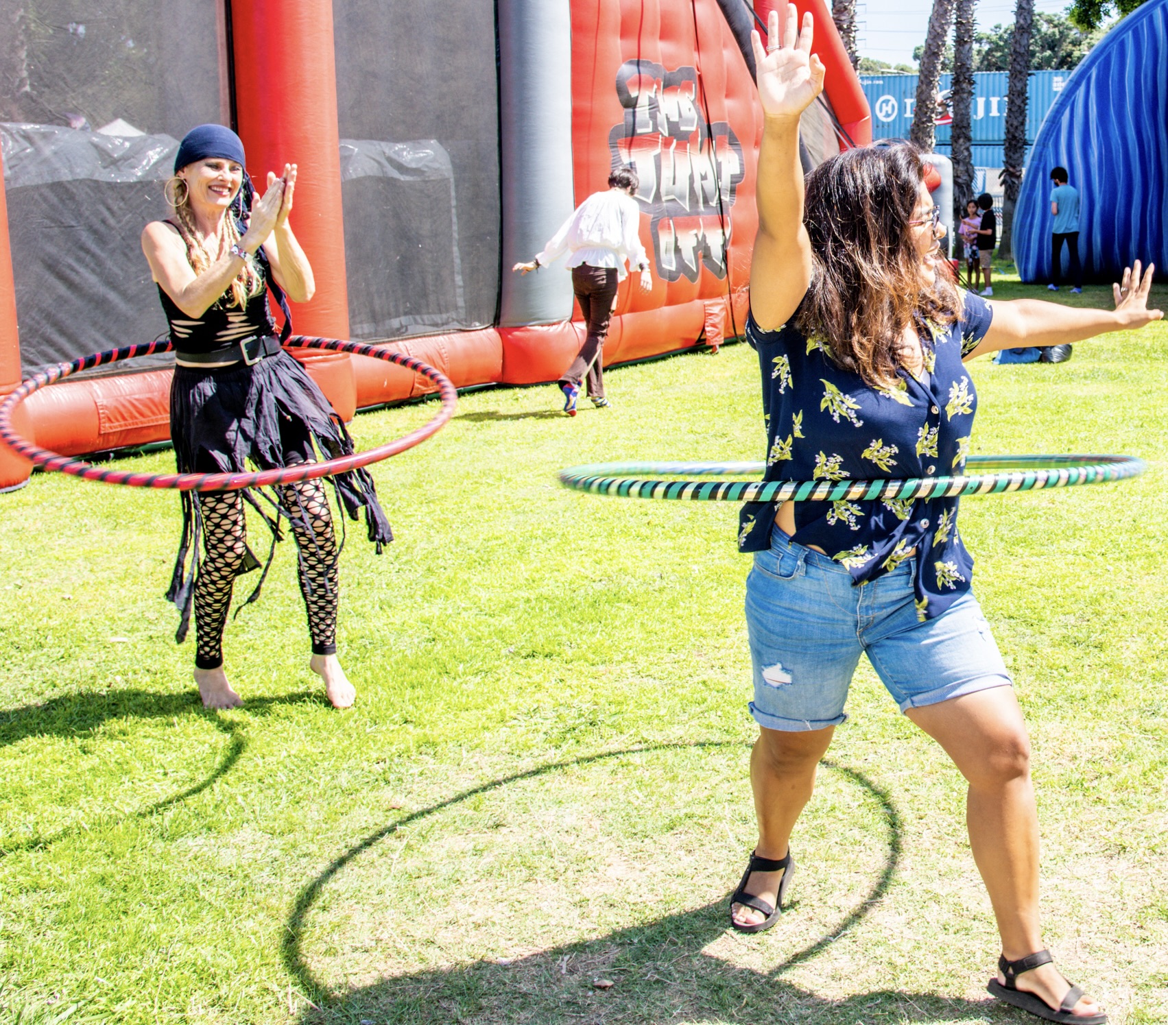 Woman hooping for the first time at a pirate festival, arms raised in joy