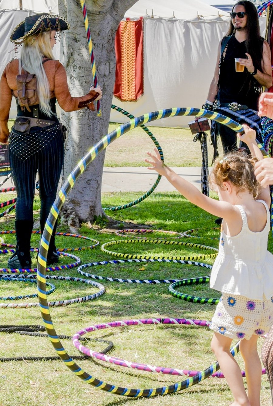 Kids reaching for colorful hula hoops at a Sunshine Hoops event